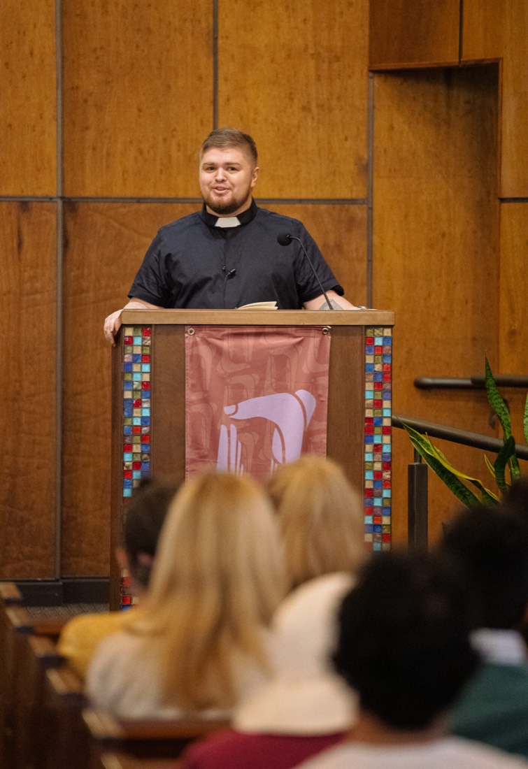 Stephen Colón preaching from a pulpit to a seated congregation