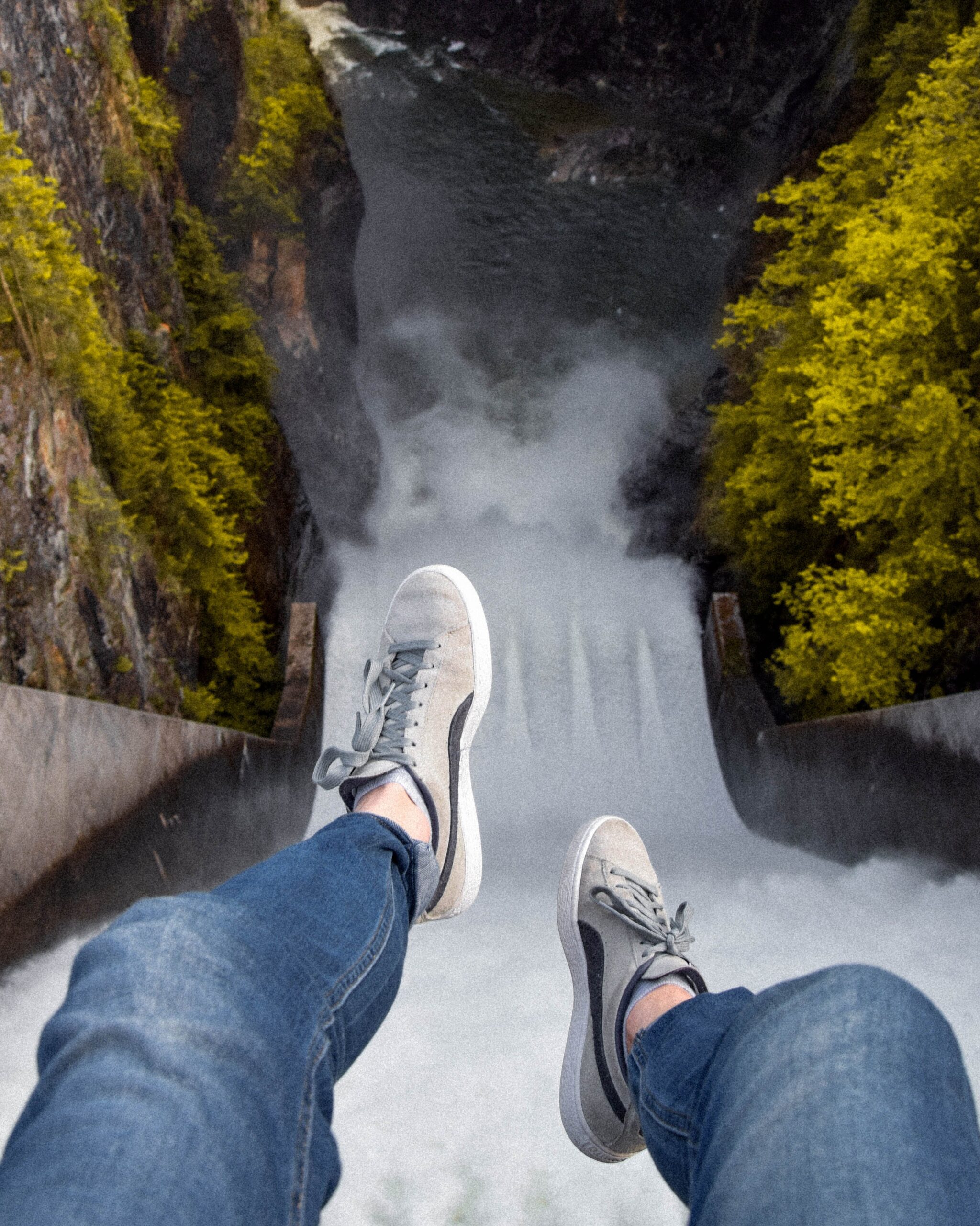 Person's Feet in Gray Sneakers Dangling Above Waterfall